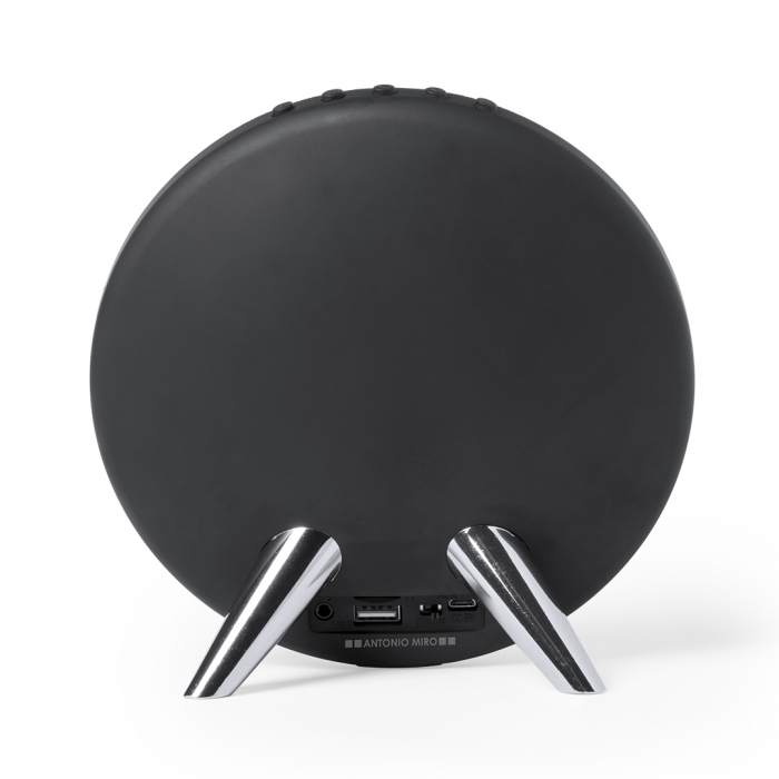 Altavoz Holsux de conexión Bluetooth® en elegante acabado de color negro con accesorioss en plateado y original diseño circular. Altavoces Bluetooth promocionales personalizados. Regalos de empresa y corporativos personalizados