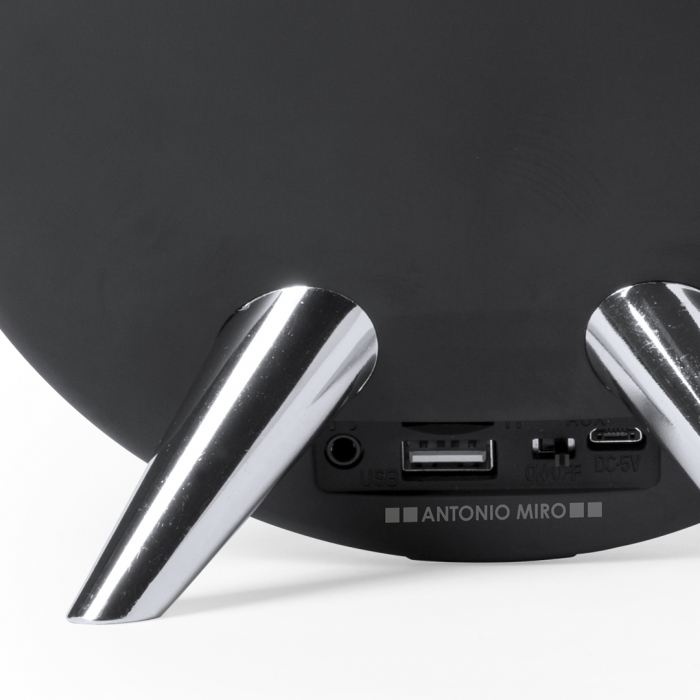 Altavoz Holsux de conexión Bluetooth® en elegante acabado de color negro con accesorioss en plateado y original diseño circular. Altavoces Bluetooth promocionales personalizados. Regalos de empresa y corporativos personalizados