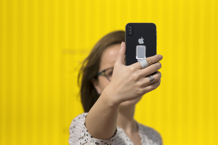 Soporte Manfix adhesivo para smartphone con cinta para selfies en resistente poliéster y pastilla central para marcaje. Soportes para móviles promocionales personalizados. Regalos de empresa y corporativos personalizados